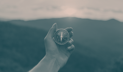 a hand holding a compass