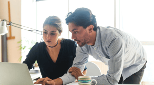 two team members working together on a computer